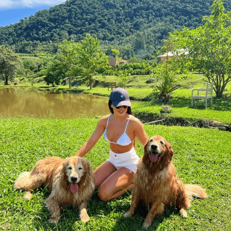 Hóspede com dois golden retrievers no gramado