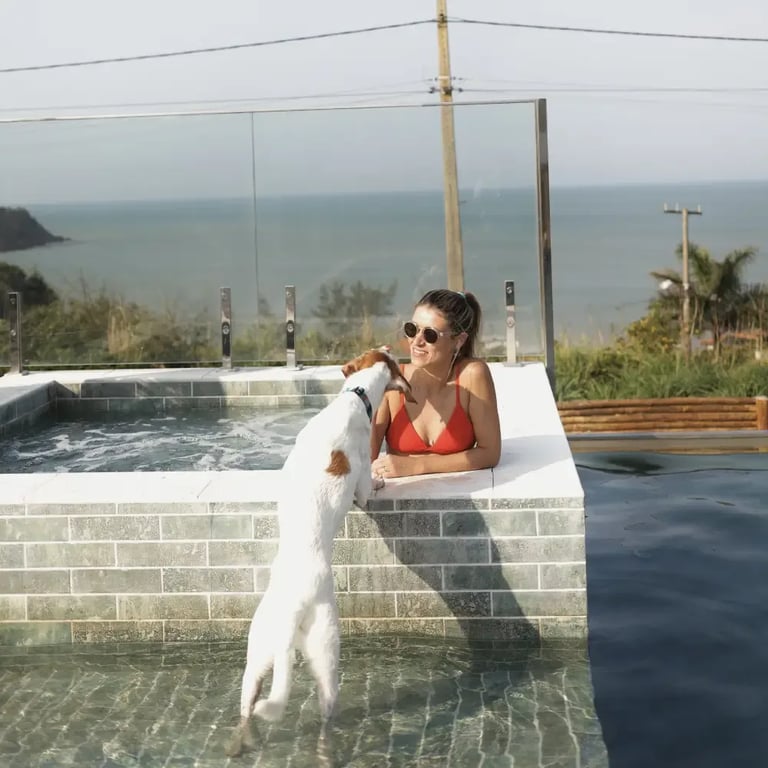 Hóspede e cachorro no ofurô com vista para o mar